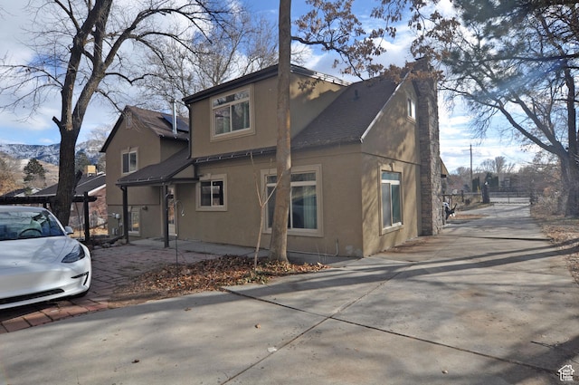 1144 E 1200 S, Ogden, UT 84404 - view of front facade featuring stucco siding, a shingled roof, driveway, and a chimney