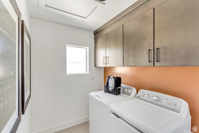 clothes washing area with washer and dryer and cabinets