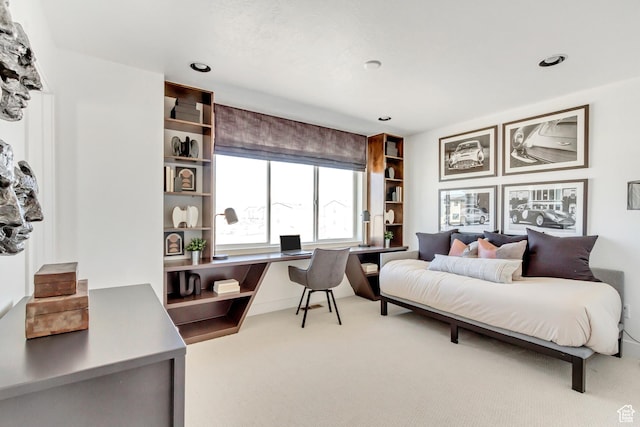 carpeted bedroom featuring built in desk