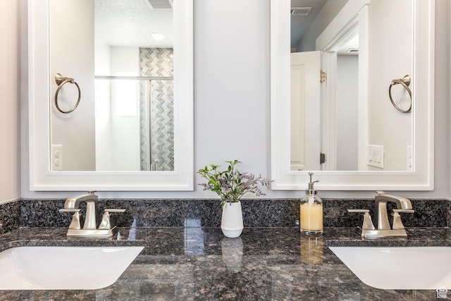 bathroom featuring a stall shower, visible vents, and a sink