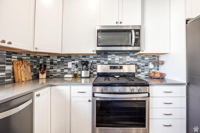 kitchen with white cabinetry, appliances with stainless steel finishes, light countertops, and backsplash