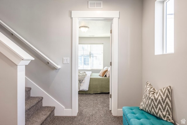 stairs with carpet floors, visible vents, and baseboards