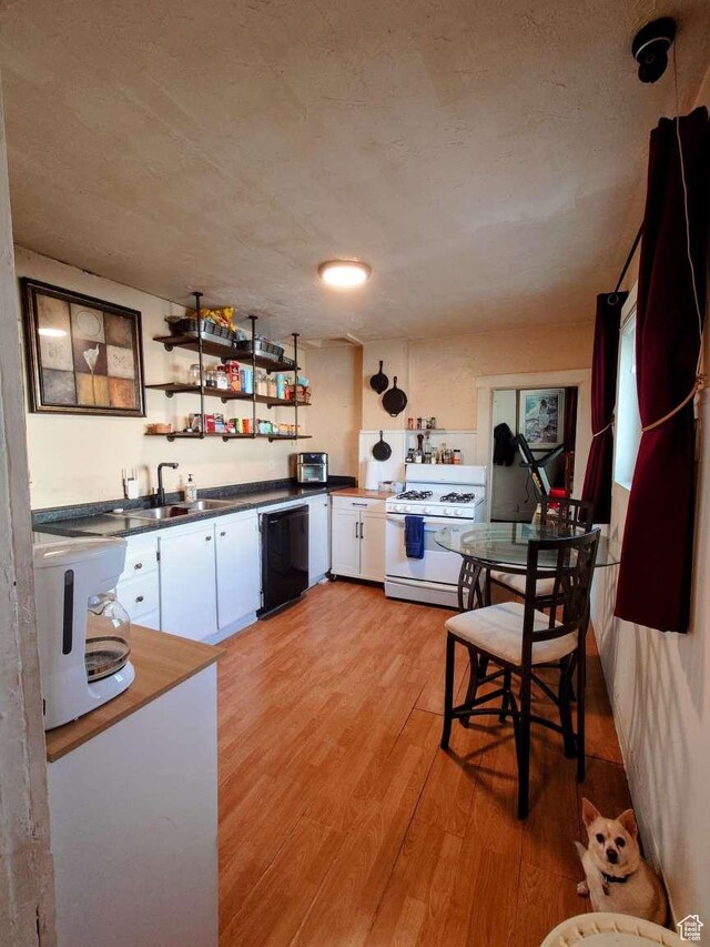 3260 Ogden Ave, Ogden, UT 84401 - kitchen with white cabinets, dishwasher, gas range gas stove, sink, and light wood-type flooring