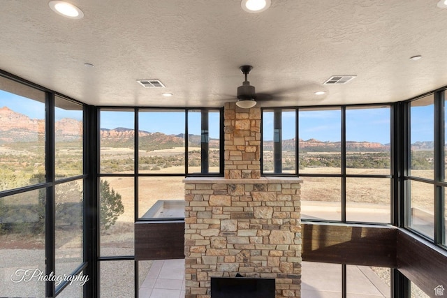 unfurnished sunroom with a mountain view and a healthy amount of sunlight