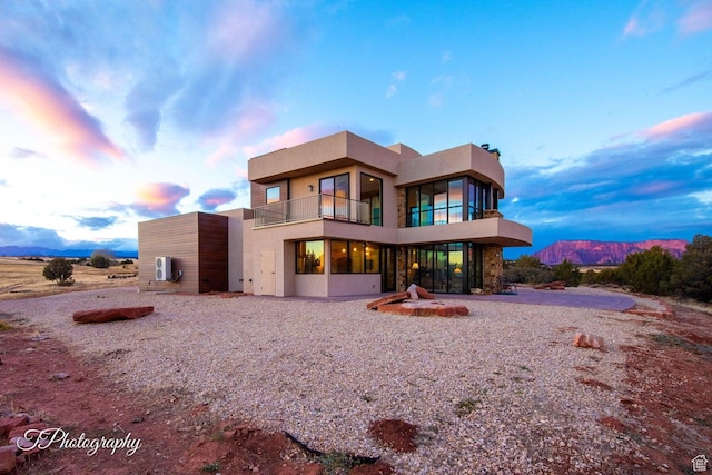 back house at dusk with a balcony and a mountain view