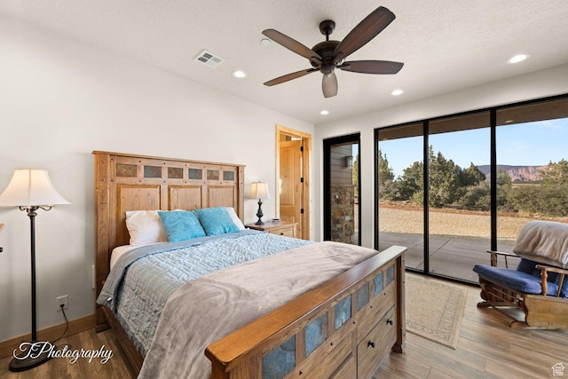 bedroom with ceiling fan, hardwood / wood-style floors, access to outside, and a textured ceiling