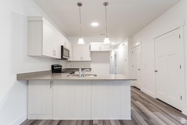 13742 S Hanley Ln Unit Gg303, Riverton, UT 84096 - kitchen with stainless steel microwave, electric range oven, a peninsula, wood finished floors, and light countertops