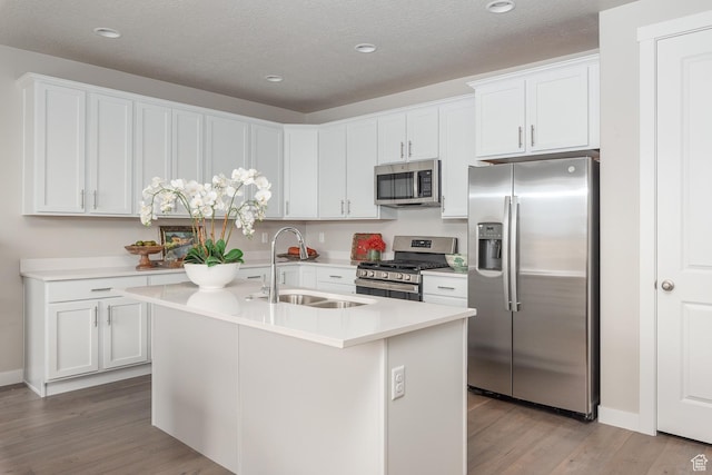 537 W Coyote Ridge Rd, Grantsville, UT 84029 - kitchen featuring sink, stainless steel appliances, white cabinets, and an island with sink