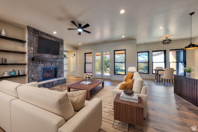 living room featuring light wood-type flooring, ceiling fan, and a fireplace