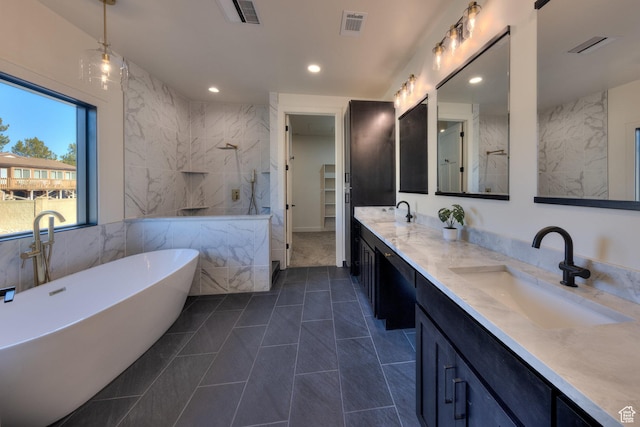 bathroom featuring a tub to relax in, tile patterned floors, and vanity