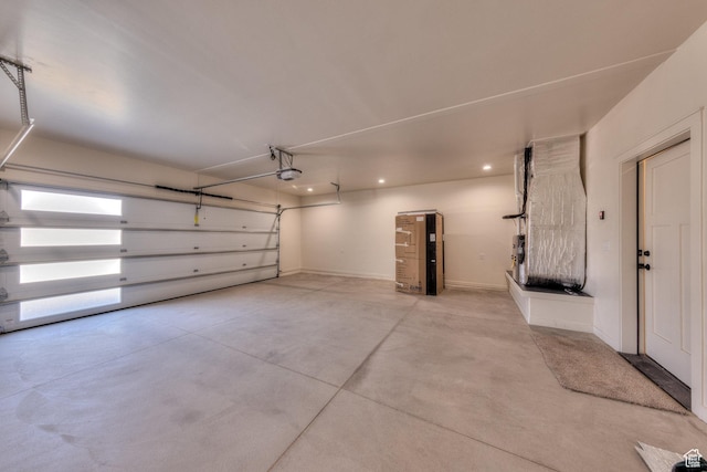 garage featuring a garage door opener and heating unit