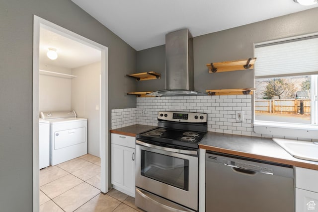 112 Arbor Dr, Moab, UT 84532 - kitchen with tasteful backsplash, light tile patterned floors, white cabinets, stainless steel appliances, and wall chimney exhaust hood