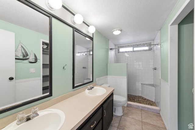 112 Arbor Dr, Moab, UT 84532 - bathroom featuring a textured ceiling, tile patterned floors, vanity, toilet, and tiled shower