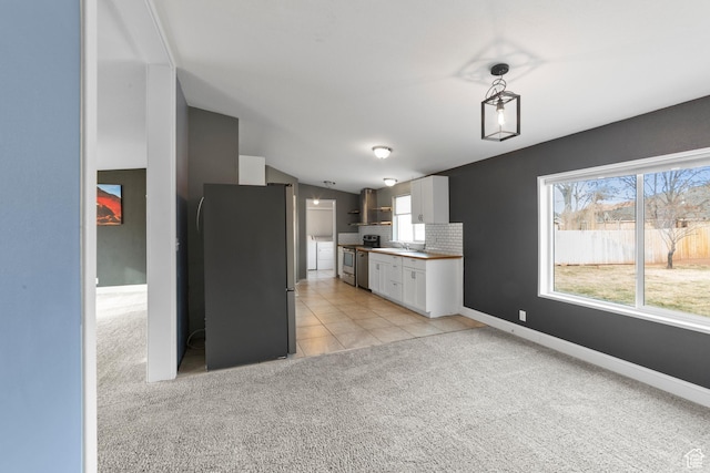 112 Arbor Dr, Moab, UT 84532 - kitchen with white cabinets, stainless steel appliances, wall chimney range hood, and a healthy amount of sunlight