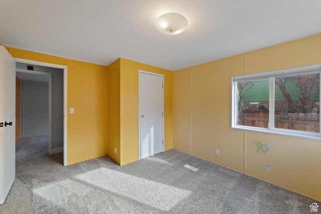 112 Arbor Dr, Moab, UT 84532 - unfurnished bedroom featuring light colored carpet, a textured ceiling, and a closet