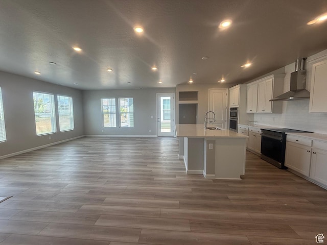 6158 W 11800 S Unit 504, South Jordan, UT 84009 - kitchen featuring wall chimney range hood, black / electric stove, open floor plan, stainless steel double oven, and light countertops