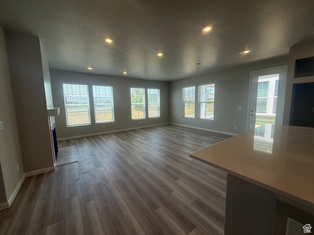 6158 W 11800 S Unit 504, South Jordan, UT 84009 - unfurnished living room with dark wood-type flooring, a fireplace, recessed lighting, and a textured ceiling