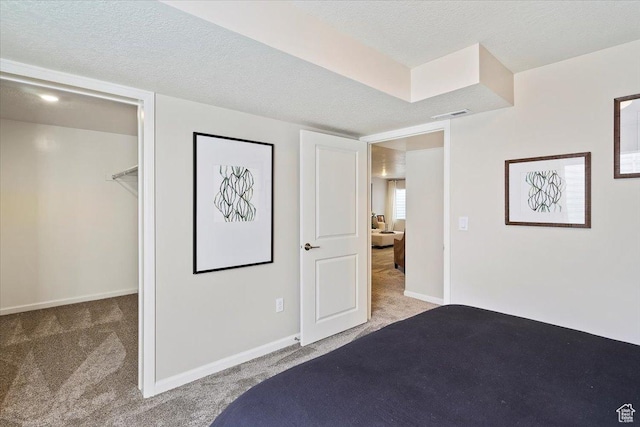 6158 W 11800 S Unit 504, South Jordan, UT 84009 - bedroom featuring carpet floors, a walk in closet, and a textured ceiling