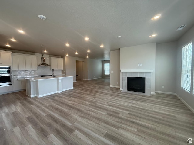 6158 W 11800 S Unit 504, South Jordan, UT 84009 - kitchen with wall chimney range hood, stainless steel double oven, open floor plan, healthy amount of natural light, and recessed lighting