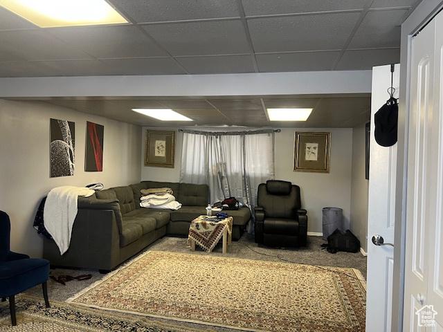 carpeted living room featuring a drop ceiling