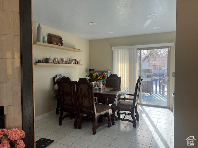 dining room featuring a textured ceiling and light tile patterned flooring