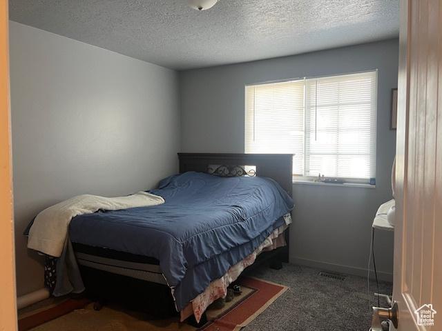 carpeted bedroom with a textured ceiling