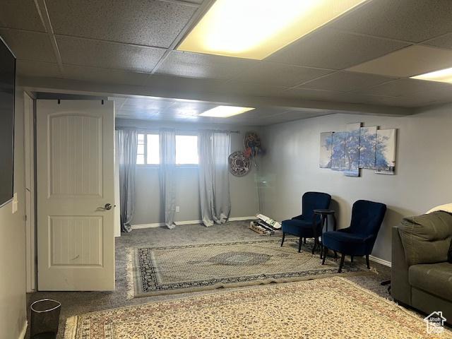 sitting room featuring a drop ceiling and carpet floors