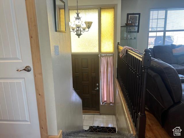 tiled foyer with a chandelier