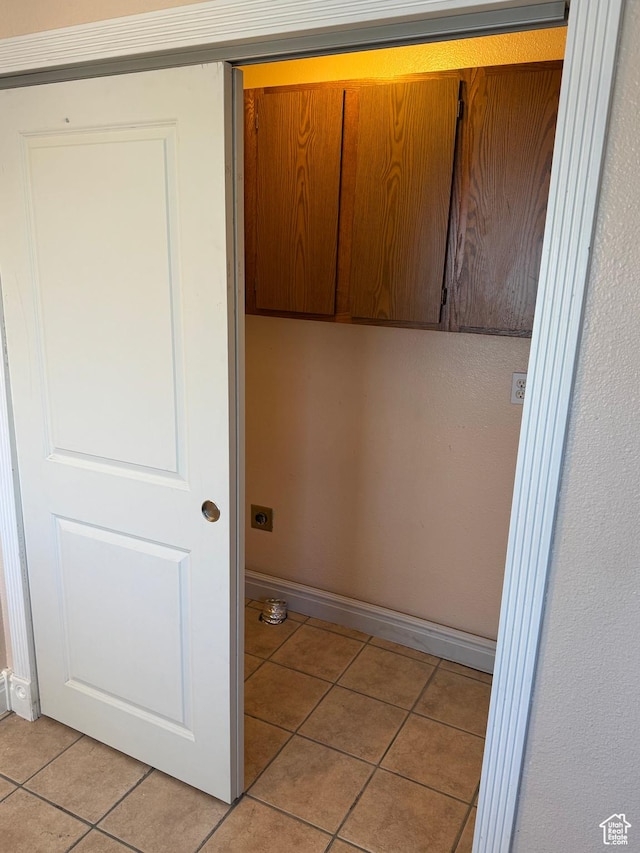 3375 S Meadowlark Dr, West Valley City, UT 84119 - laundry room featuring light tile patterned floors, baseboards, and cabinet space