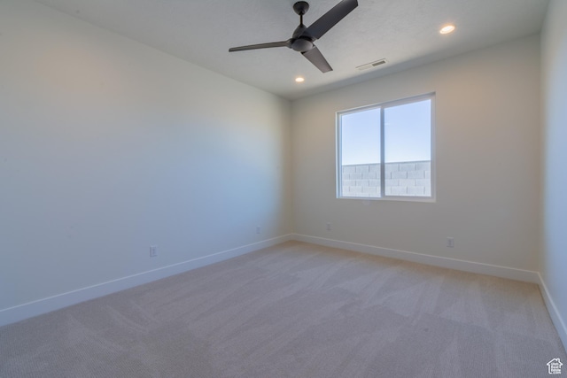 spare room featuring ceiling fan and light colored carpet