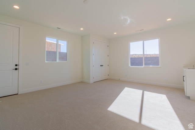 spare room with light carpet and a healthy amount of sunlight
