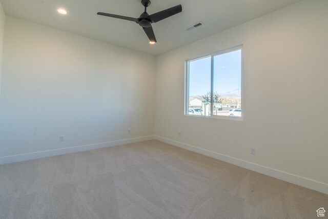 spare room featuring light carpet and ceiling fan