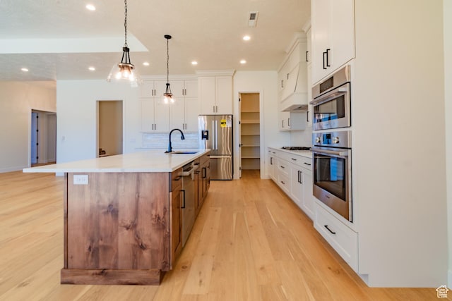 kitchen featuring white cabinets, stainless steel refrigerator with ice dispenser, decorative backsplash, sink, and a large island