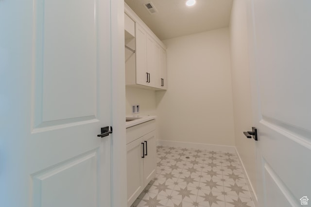 laundry area featuring hookup for a washing machine and cabinets