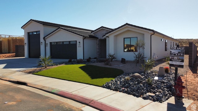 ranch-style home featuring a garage and a front lawn
