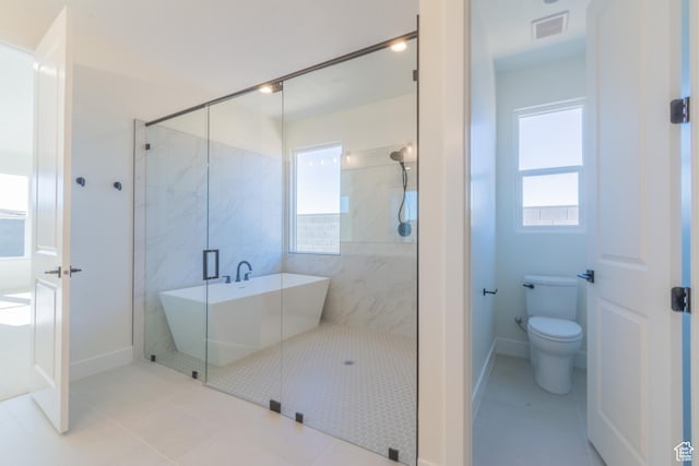 bathroom featuring toilet, tile patterned floors, and shower with separate bathtub