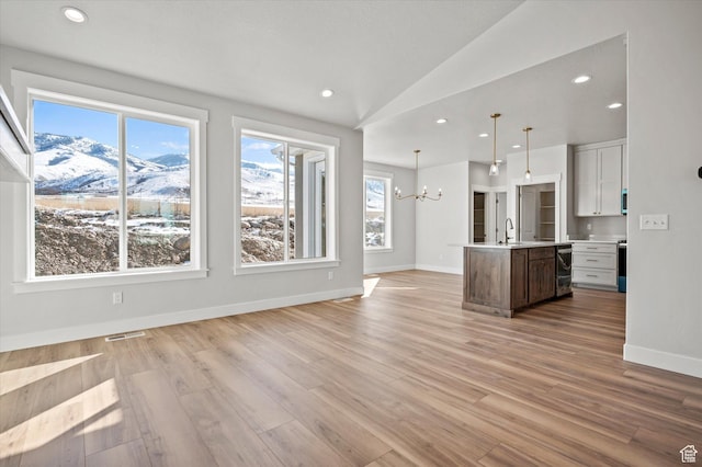 354 S 1150 E Unit 605, Smithfield, UT 84335 - unfurnished living room featuring a mountain view, visible vents, an inviting chandelier, and plenty of natural light