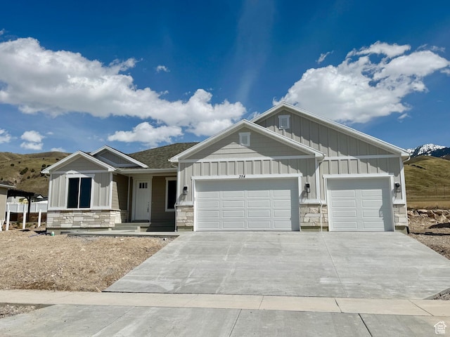 354 S 1150 E Unit 605, Smithfield, UT 84335 - view of front facade with stone siding, board and batten siding, driveway, and an attached garage