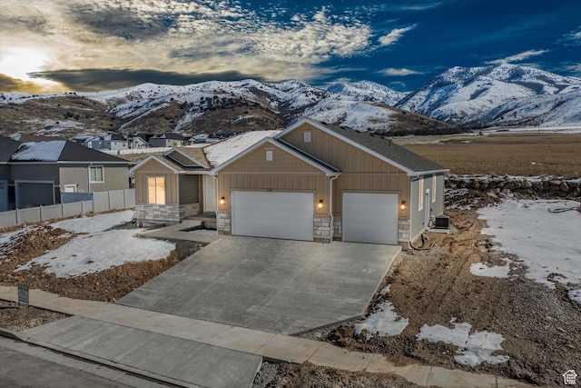 354 S 1150 E Unit 605, Smithfield, UT 84335 - view of front facade featuring driveway, a mountain view, an attached garage, and stone siding