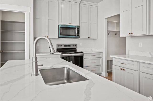 354 S 1150 E Unit 605, Smithfield, UT 84335 - kitchen featuring white cabinets, stainless steel appliances, light stone counters, and a sink
