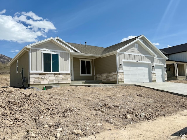354 S 1150 E Unit 605, Smithfield, UT 84335 - view of front of house featuring a garage, board and batten siding, concrete driveway, and stone siding