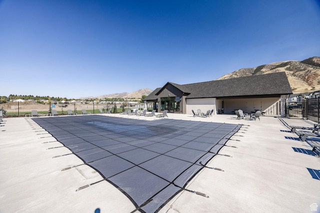 view of swimming pool with a mountain view and a patio area