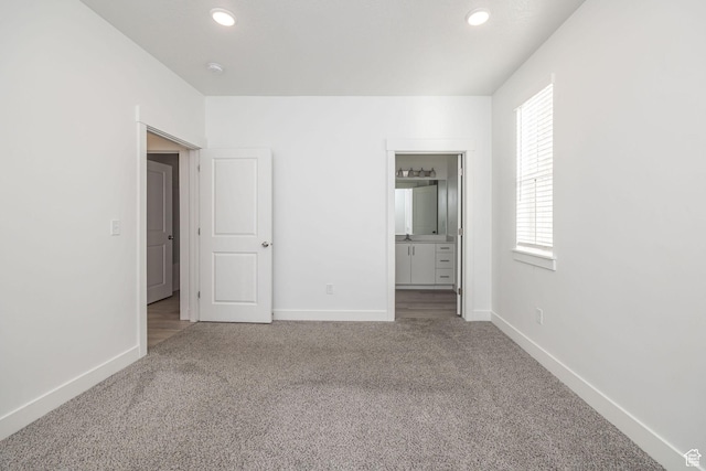 unfurnished bedroom featuring connected bathroom and carpet flooring