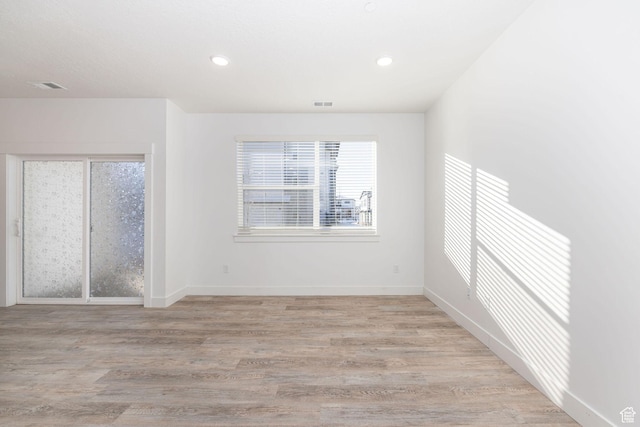 empty room with light hardwood / wood-style floors and a wealth of natural light