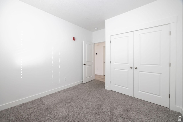unfurnished bedroom featuring carpet flooring and a closet