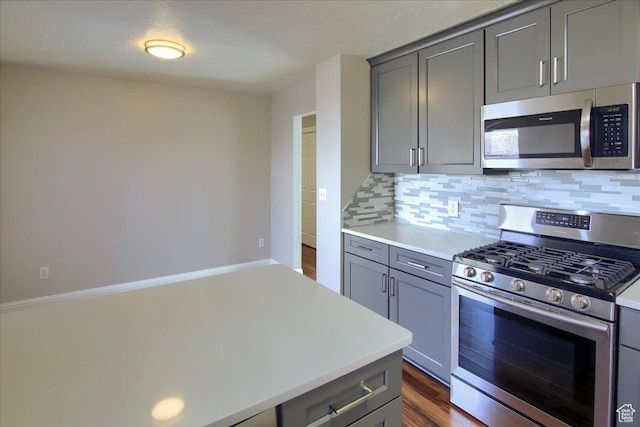 4698 Porter Ave, South Ogden, UT 84403 - kitchen with dark wood-type flooring, appliances with stainless steel finishes, gray cabinets, and tasteful backsplash