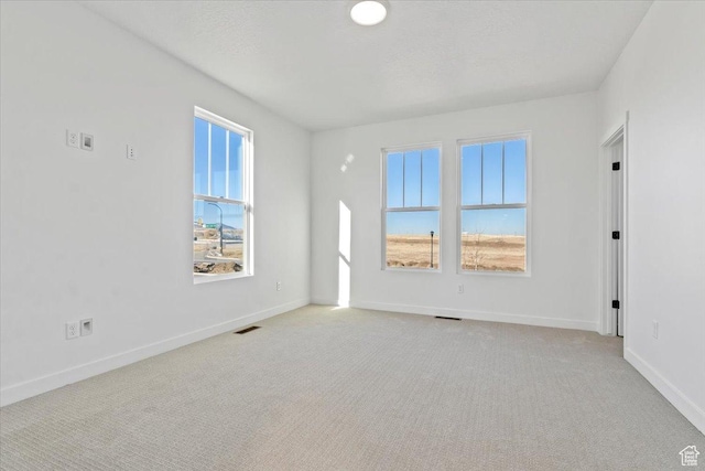carpeted empty room featuring baseboards