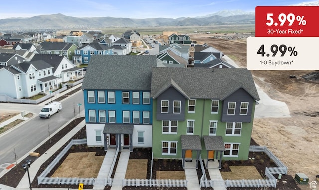 view of front of house with a mountain view, roof with shingles, a residential view, and stucco siding