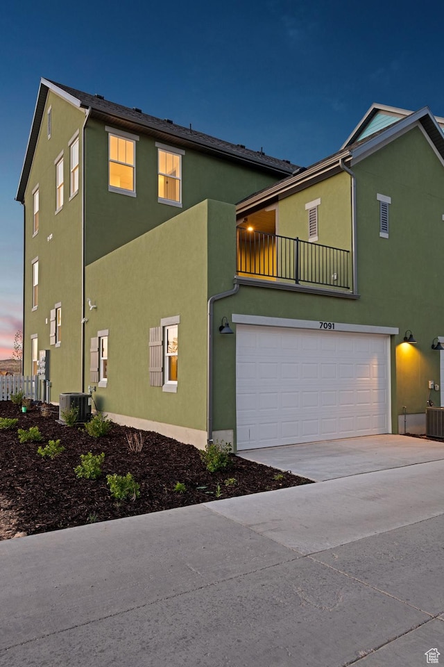7091 W S Jordan Pkwy Unit 394, South Jordan, UT 84009 - view of front of house featuring stucco siding, a garage, central AC, driveway, and a balcony
