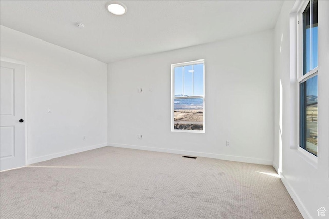 carpeted empty room with baseboards and a smoke detector